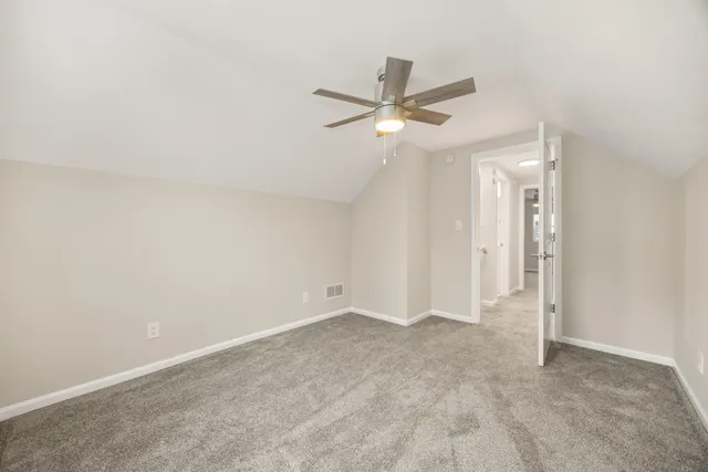an empty room with a ceiling fan and a window