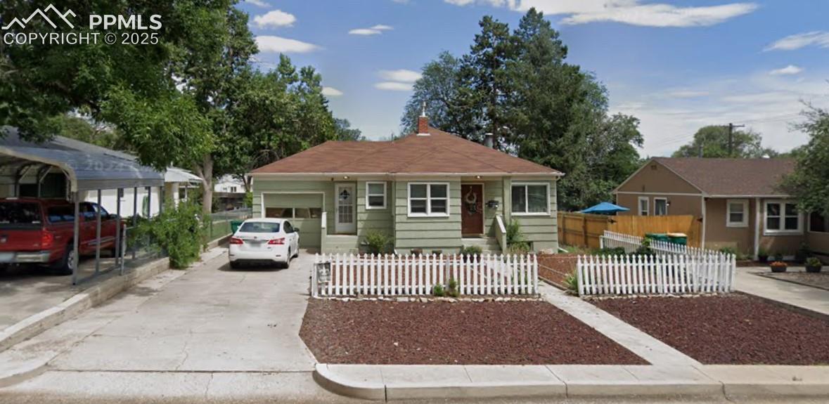 Bungalow-style house with a fenced front yard and concrete driveway