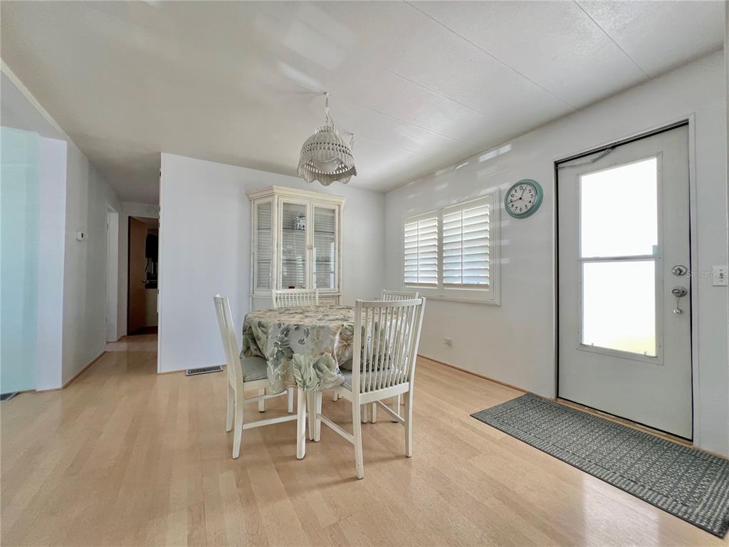 1100 South Belcher Road, Unit 57 Largo, FL 33771 - Photo 34 of 59 a dining room with furniture a chandelier and wooden floor