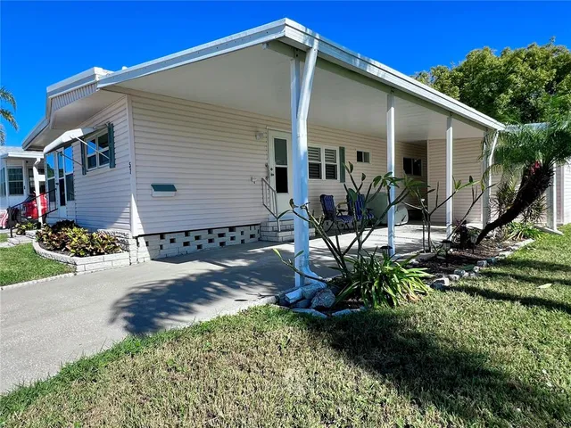 a view of a house with backyard and sitting area