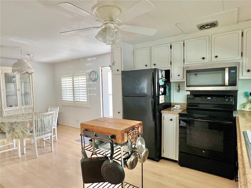 1100 South Belcher Road, Unit 57 Largo, FL 33771 - Photo 10 of 59 a kitchen with a refrigerator a stove a dining table and chairs