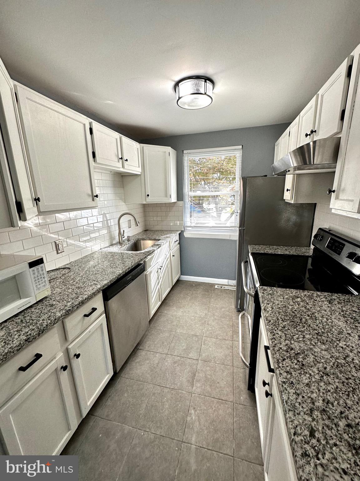 326 Brandon Drive Bear, DE 19701 - Photo 5 of 16 a kitchen with granite countertop a sink stove and cabinets