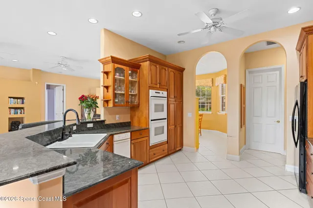 a kitchen with stainless steel appliances granite countertop a sink a stove and a refrigerator