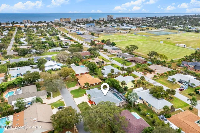 an aerial view of a house with a yard and large trees