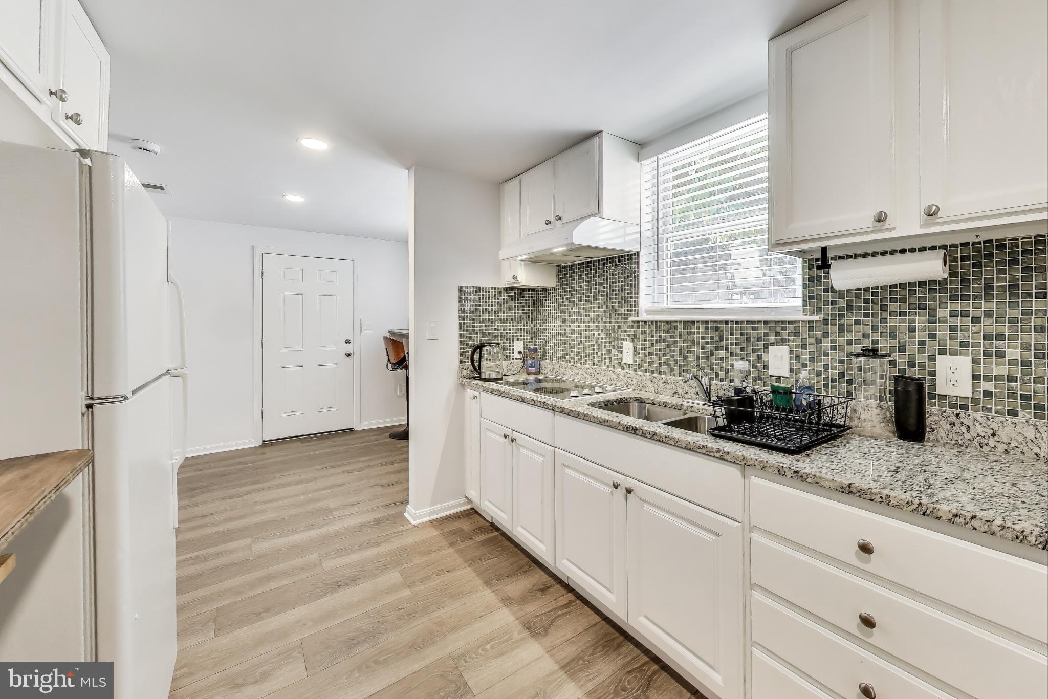 3100 North Glebe Road Arlington, VA 22207 - Photo 58 of 101 a kitchen with granite countertop white cabinets and white appliances