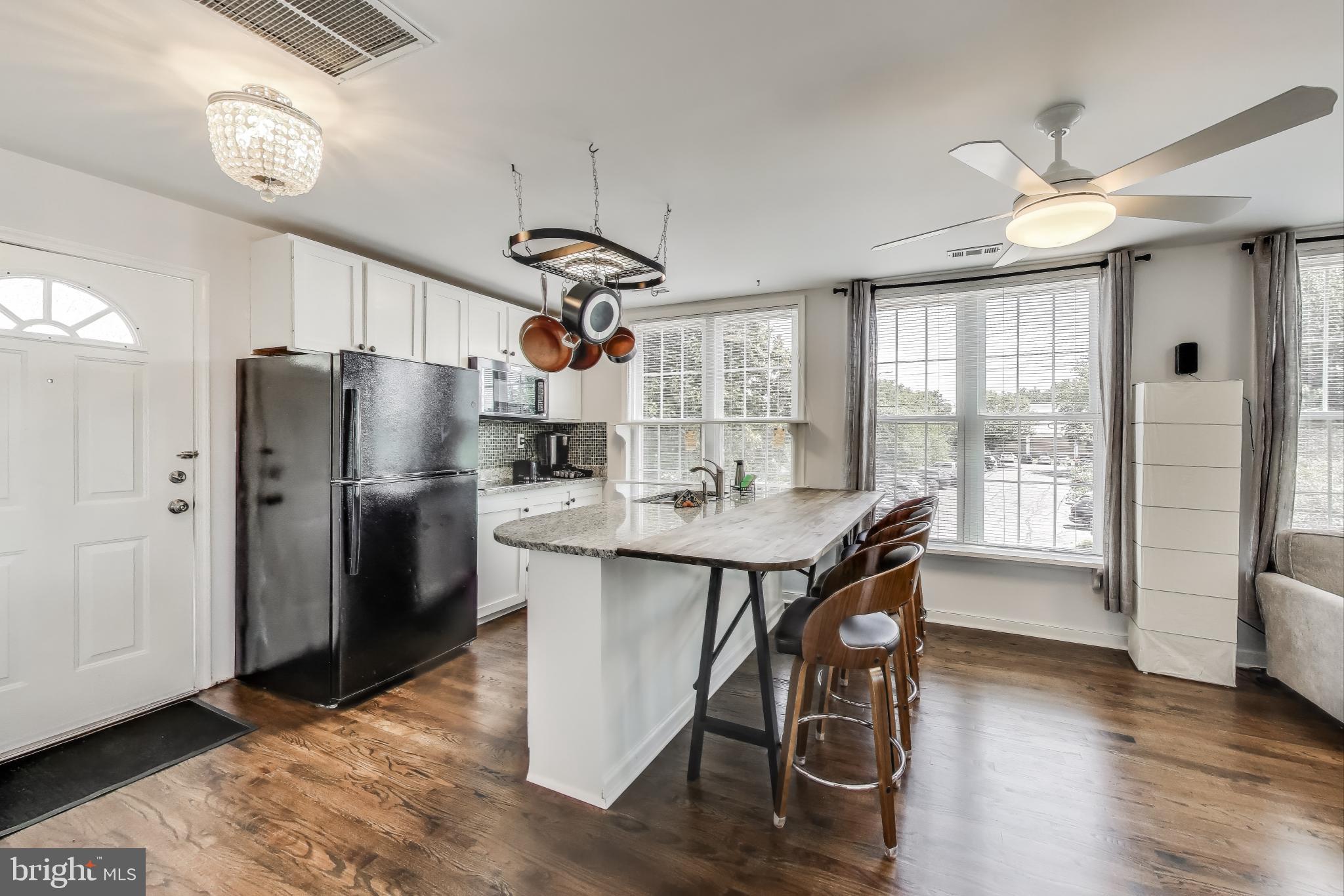 3100 North Glebe Road Arlington, VA 22207 - Photo 67 of 101 a kitchen with stainless steel appliances a table chairs and refrigerator