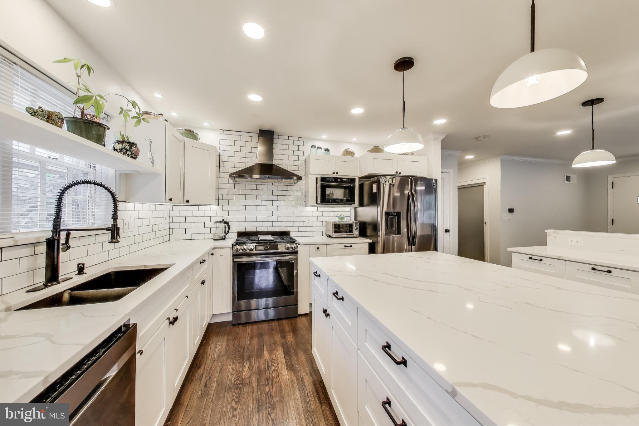 3100 North Glebe Road Arlington, VA 22207 - Photo 7 of 101 a large kitchen with stainless steel appliances kitchen island a stove a sink a refrigerator and a kitchen island with wooden floor