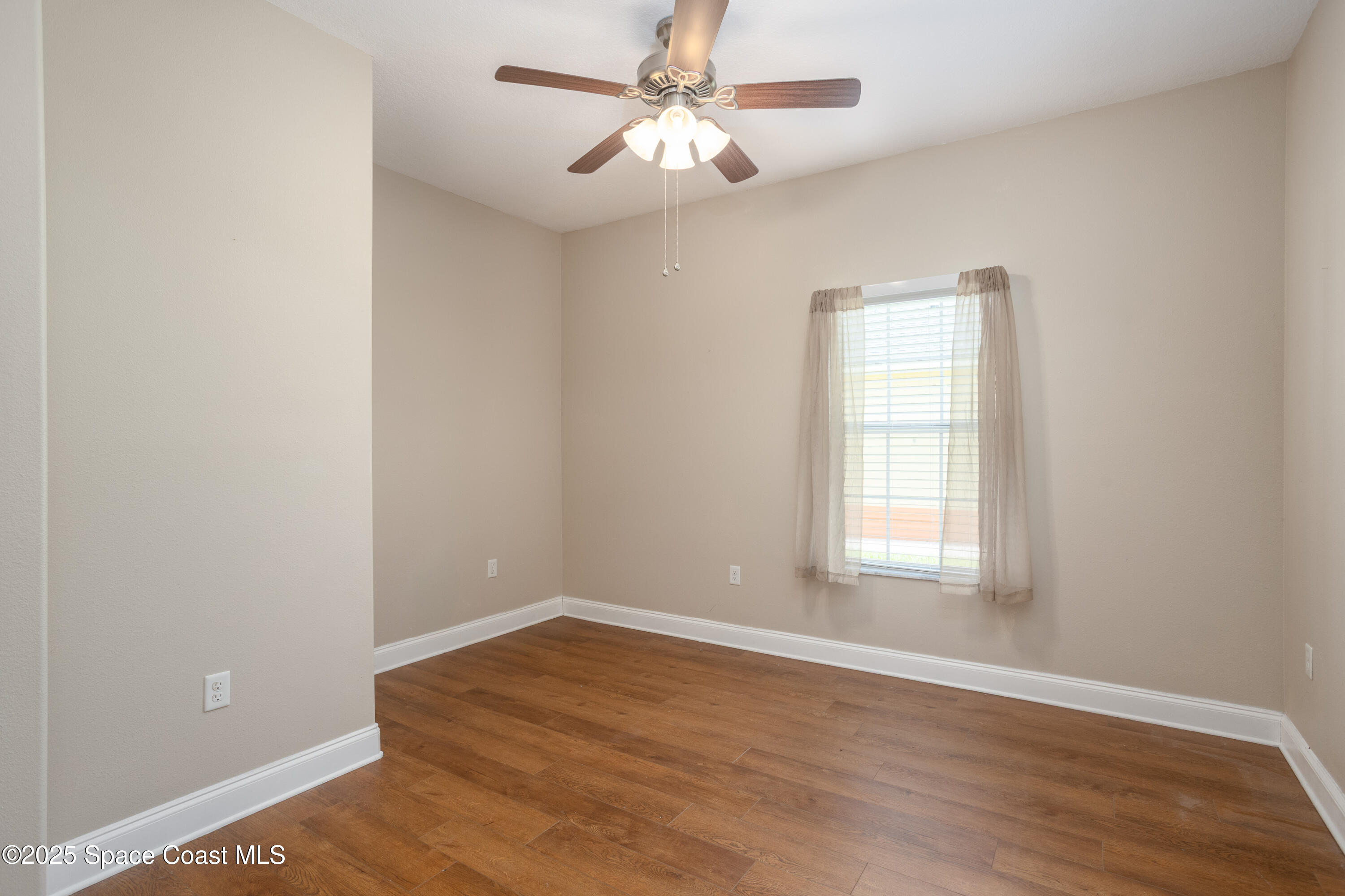 3029 Vallejo Way Melbourne, FL 32940 - Photo 11 of 26 wooden floor in an empty room with a window
