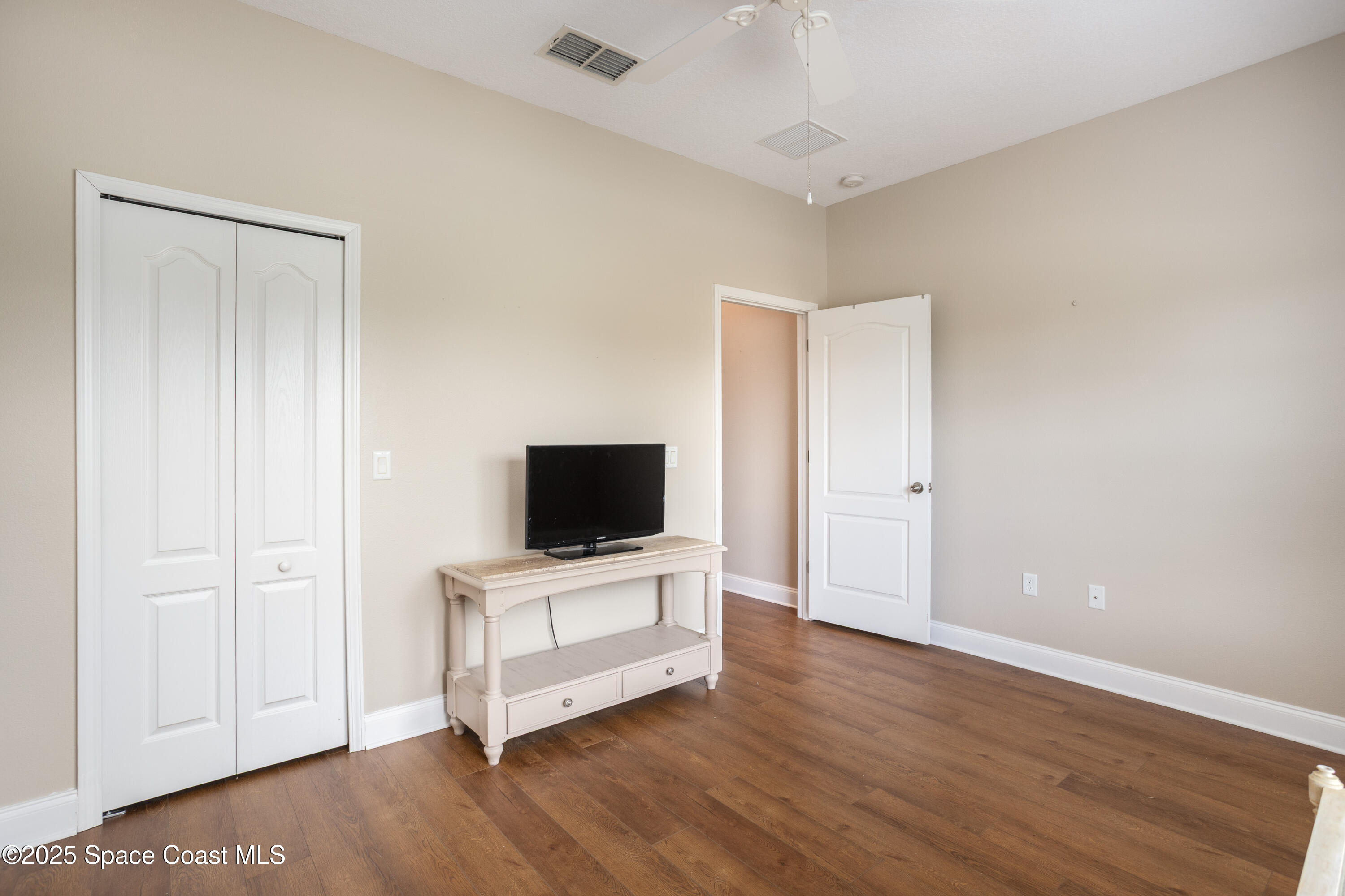 3029 Vallejo Way Melbourne, FL 32940 - Photo 17 of 26 a view of a livingroom with wooden floor and a flat screen tv