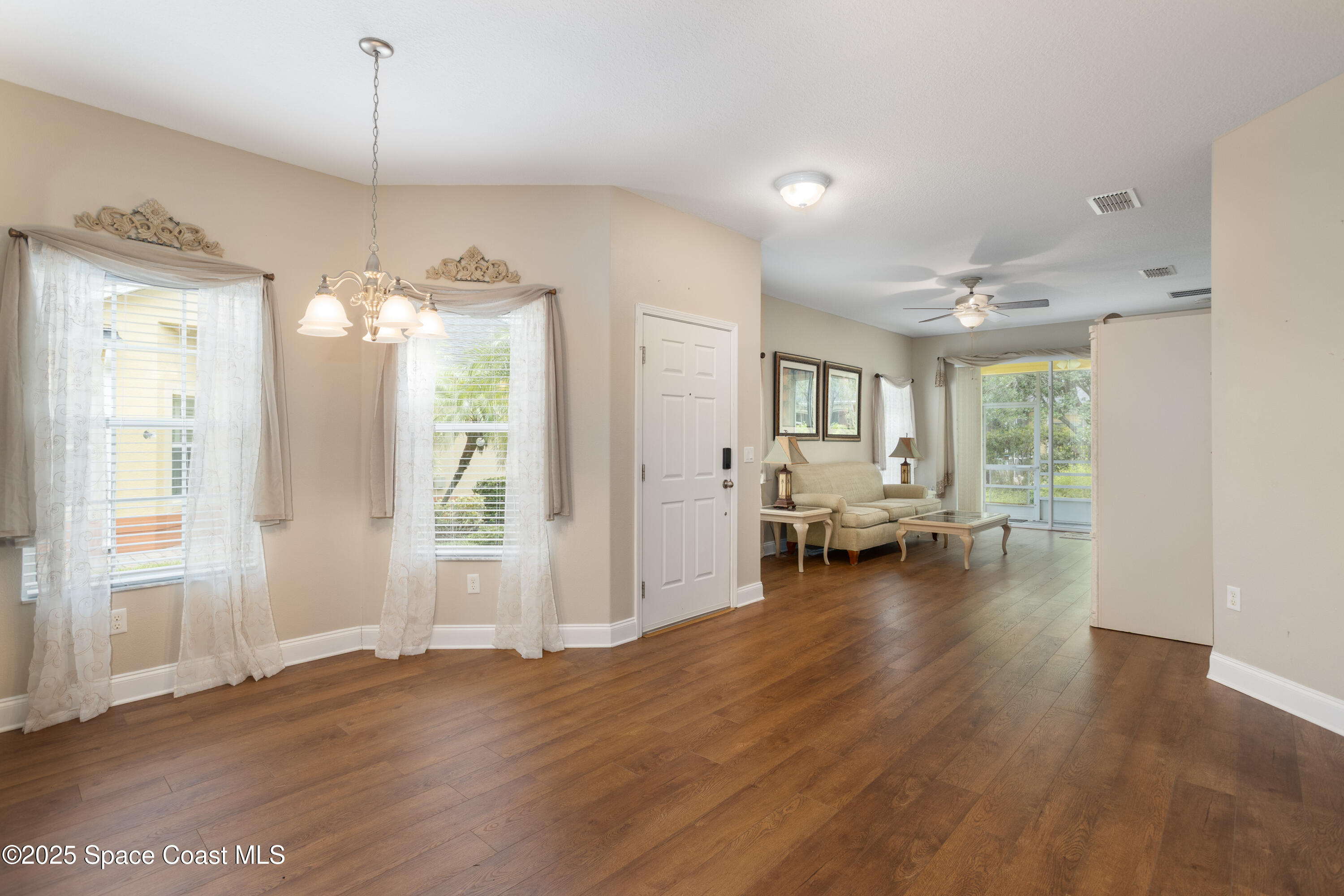 3029 Vallejo Way Melbourne, FL 32940 - Photo 7 of 26 a living room with furniture and a chandelier