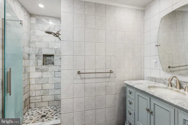 a bathroom with a sink shower and a mirror