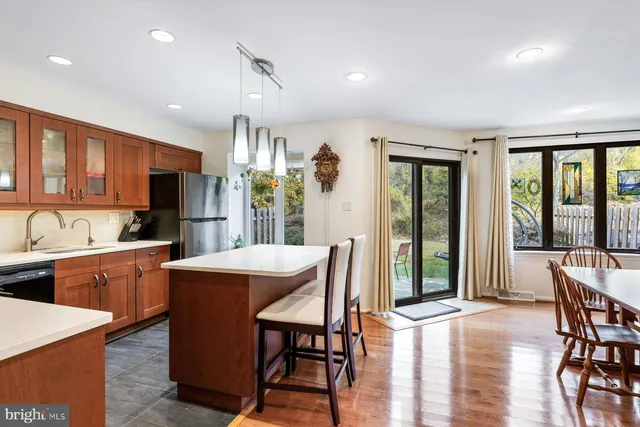 a kitchen with stainless steel appliances granite countertop a table chairs sink refrigerator and cabinets