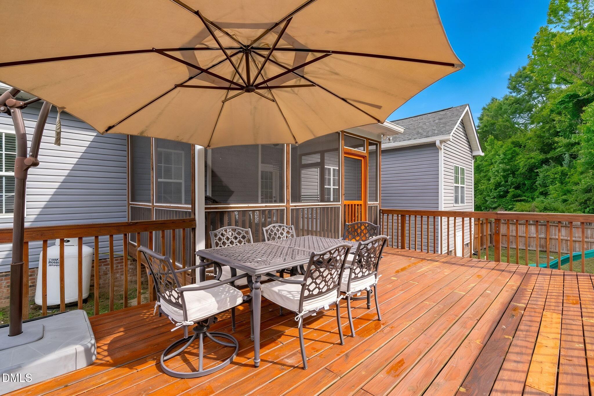 2450 Rolling Tracks Road Willow Spring, NC 27592 - Photo 48 of 64 a view of a deck with wooden floor and outdoor seating
