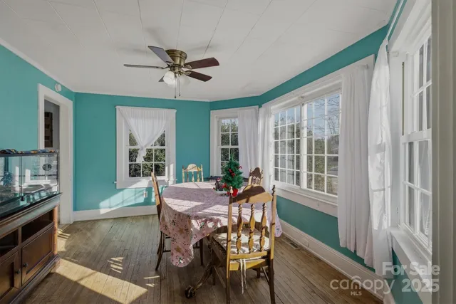 a dining room with furniture a window and wooden floor