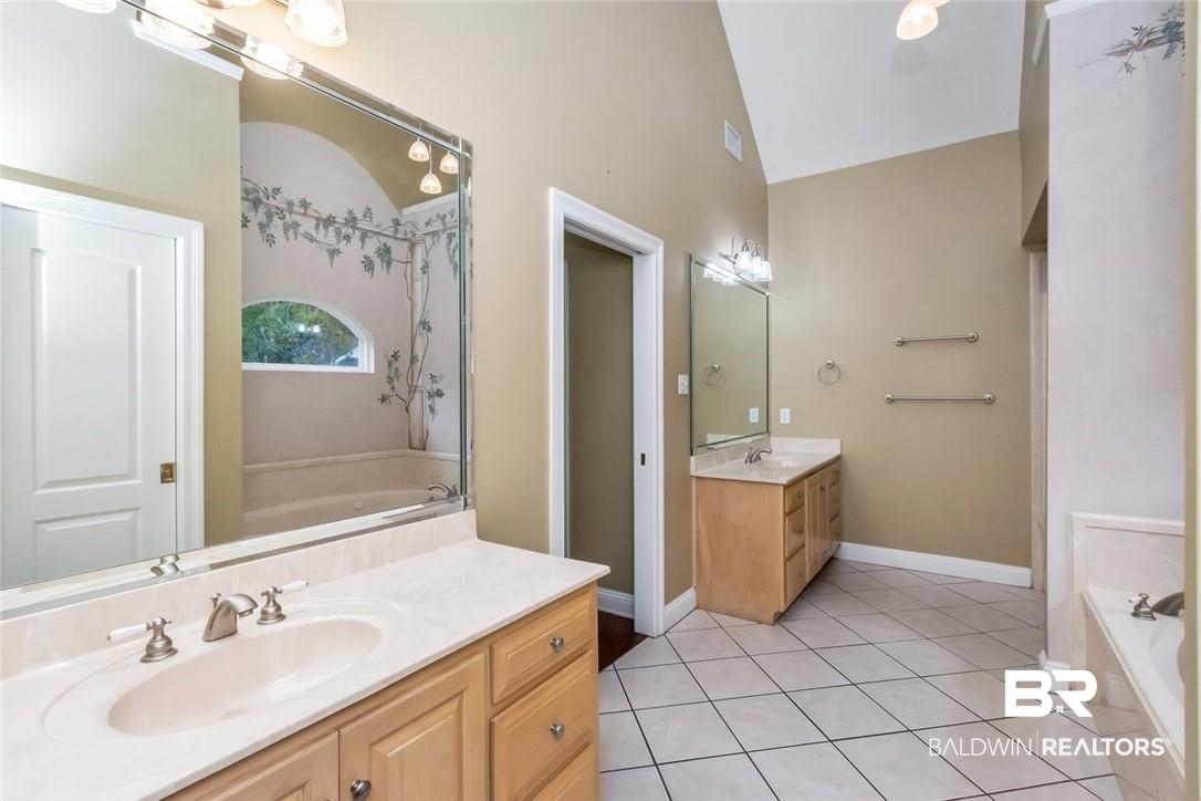 8837 Dawes Lake Road South Mobile, AL 36619 - Photo 21 of 44 Bathroom featuring lofted ceiling, a tub to relax in, tile patterned flooring, and vanity
