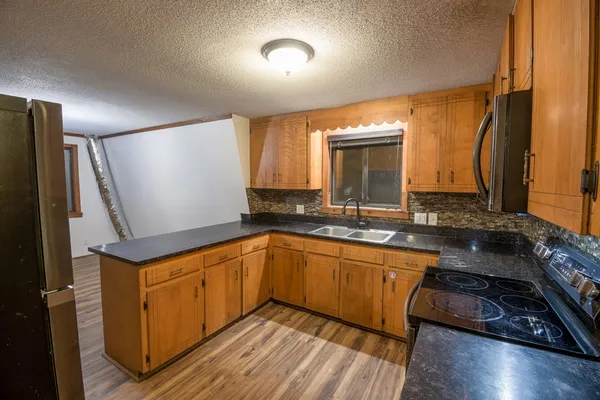 a kitchen with sink cabinets and wooden floor
