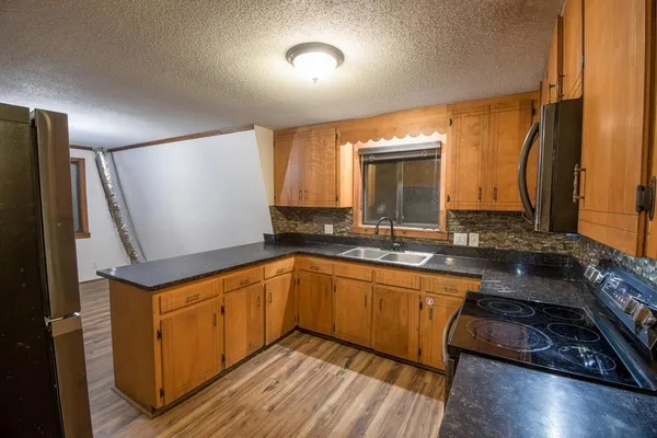 a kitchen with sink cabinets and wooden floor