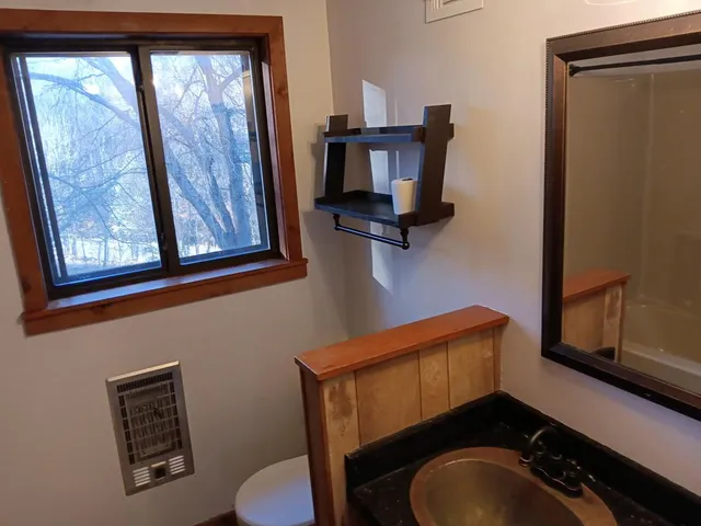 a bathroom with a toilet mirror and vanity