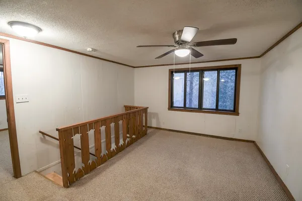 an empty room with windows and fan