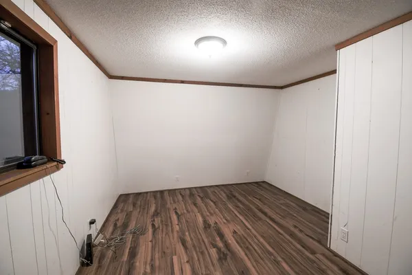 a view of small space with wooden floor and fan