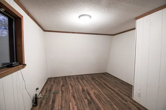 a view of small space with wooden floor and fan