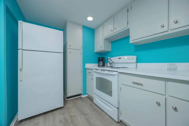 a kitchen with cabinets and a refrigerator