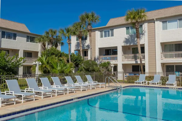 a view of a house with pool and chairs