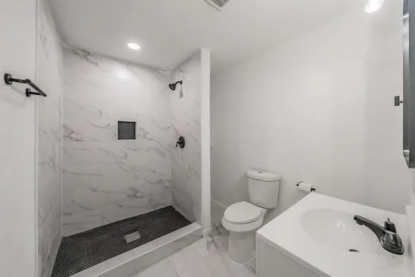 a bathroom with a sink toilet and shower