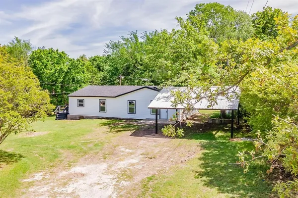 a view of a house with a yard and trees