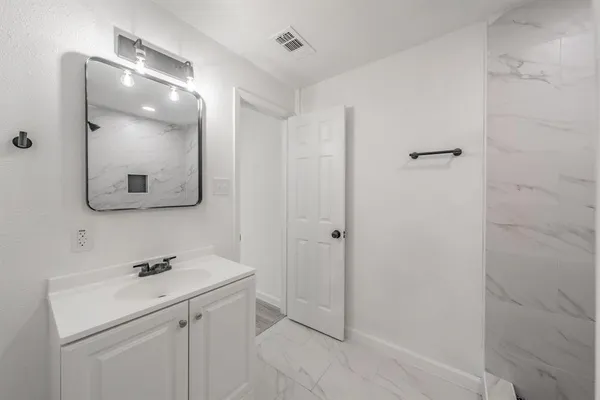a bathroom with a sink a light fixture and a mirror