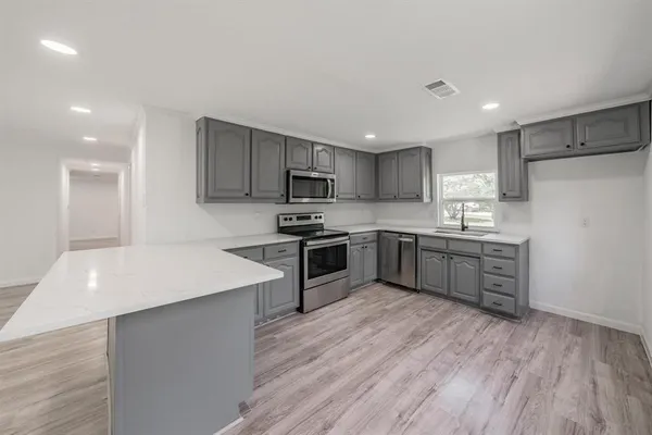 a kitchen with a white cabinets and stainless steel appliances