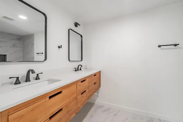 a bathroom with 2 sink and a mirror