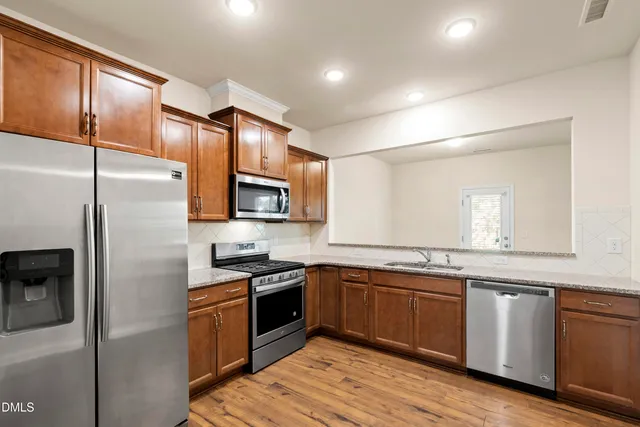 a kitchen with stainless steel appliances granite countertop a sink stove and refrigerator
