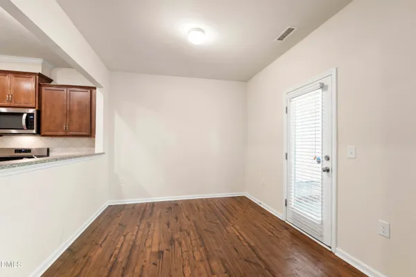 a view of a kitchen with wooden floor and electronic appliances