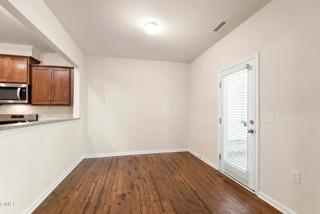 a view of a kitchen with wooden floor and electronic appliances