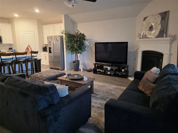 a living room with furniture a flat screen tv and a fireplace