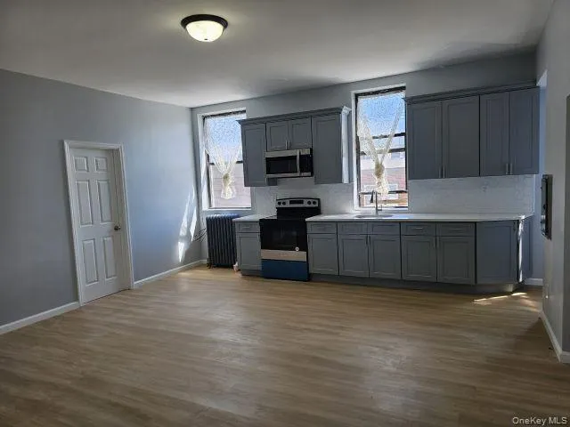 a view of kitchen with kitchen island microwave and wooden floor