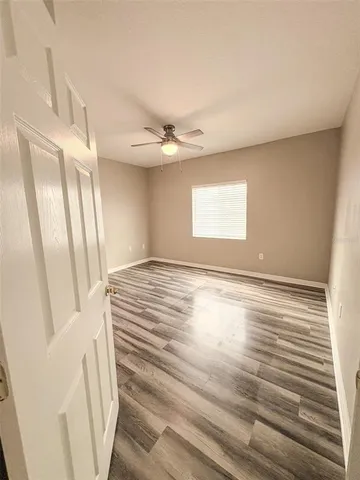 a view of a bedroom with wooden floor and a bathroom