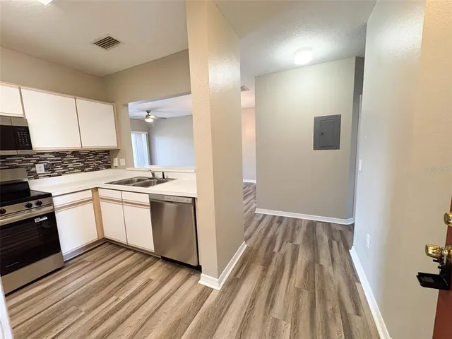 a white kitchen with a stove top oven and sink