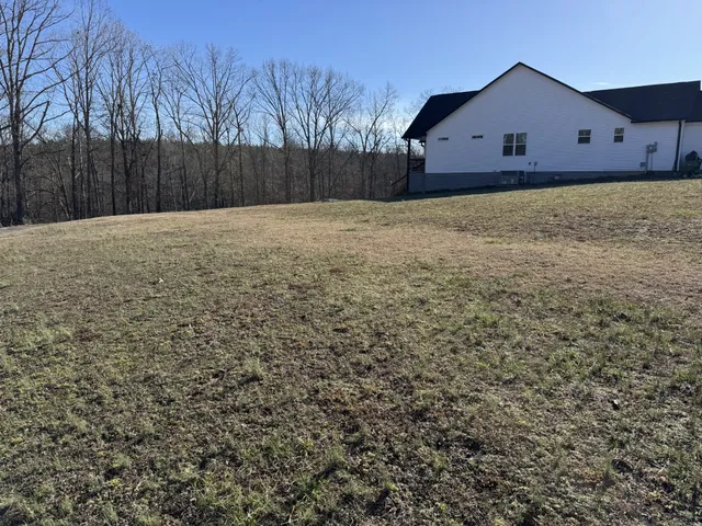 a view of a house with a yard and wooden fence