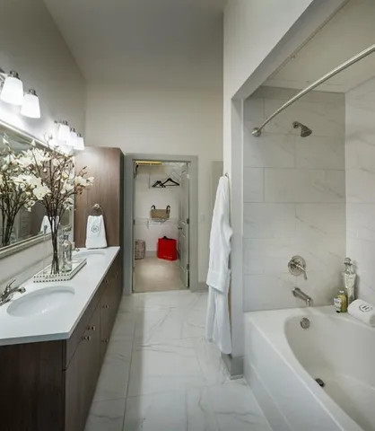 a bathroom with a tub sink and mirror