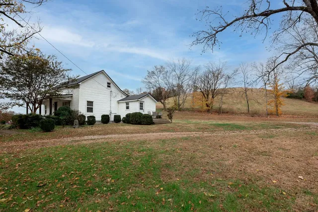 a view of a white house with a yard