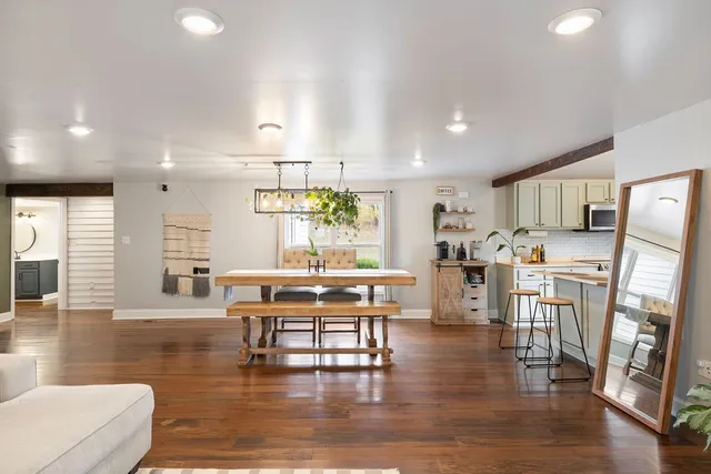 a room with stainless steel appliances wooden floor and large windows