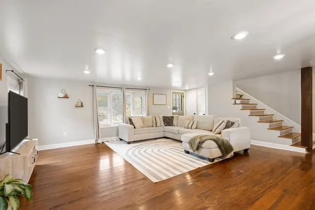 a living room with furniture window and wooden floor