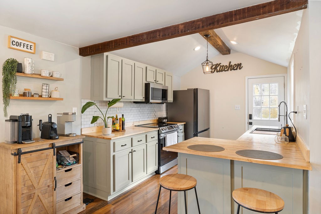 1200 Wray Branch Road Minor Hill, TN 38473 - Photo 5 of 29 a kitchen with stainless steel appliances a sink a stove a refrigerator cabinets and a dining table