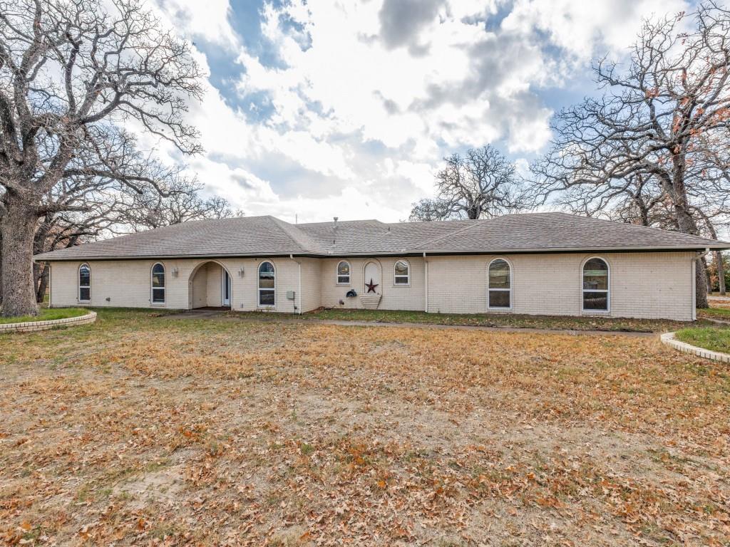 7325 Reed Road Azle, TX 76020 - Photo 1 of 38 Rear view of property with a shingled roof, a yard, and brick siding