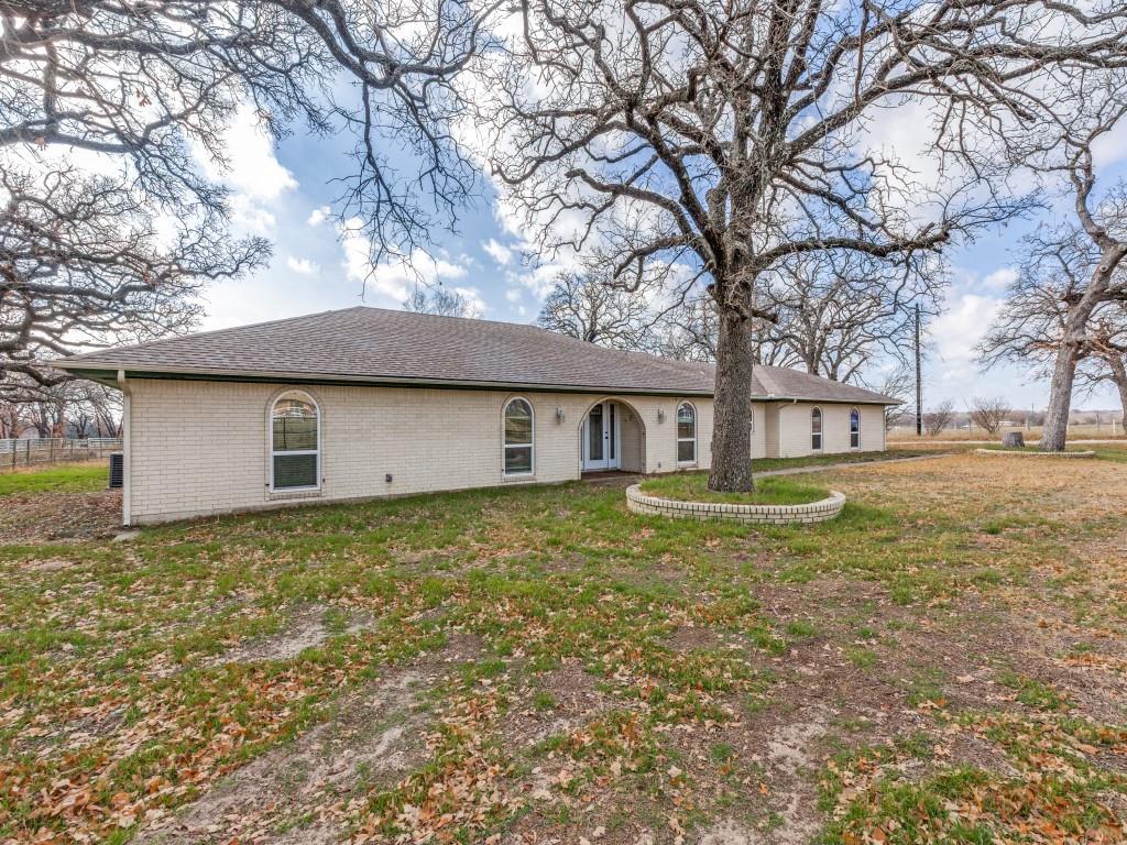 7325 Reed Road Azle, TX 76020 - Photo 2 of 38 View of front of property with roof with shingles, brick siding, and a front yard