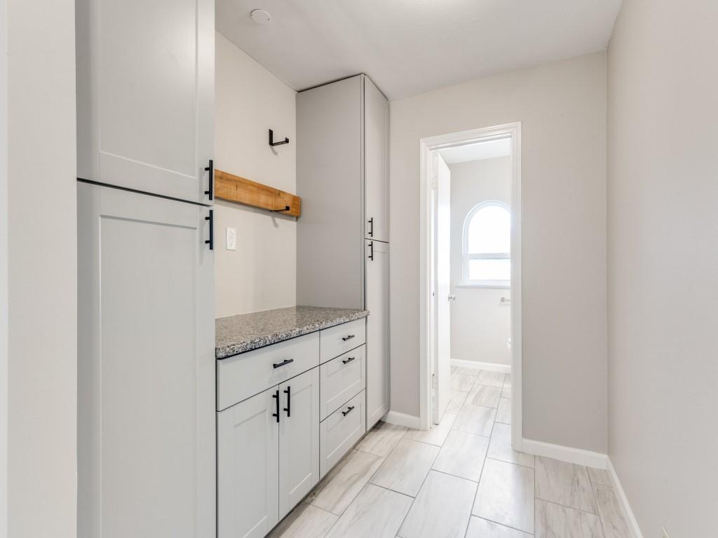 7325 Reed Road Azle, TX 76020 - Photo 32 of 38 Kitchen featuring light stone countertops, open shelves, and white cabinetry