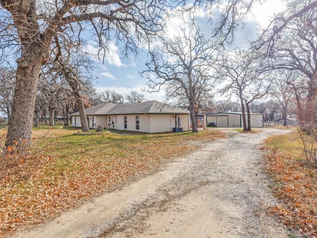 7325 Reed Road Azle, TX 76020 - Photo 4 of 38 View of property exterior featuring driveway and a yard