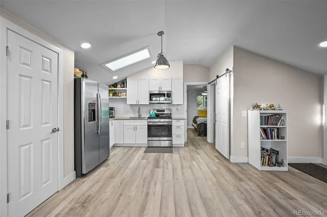 a kitchen with stainless steel appliances granite countertop a refrigerator and a stove top oven